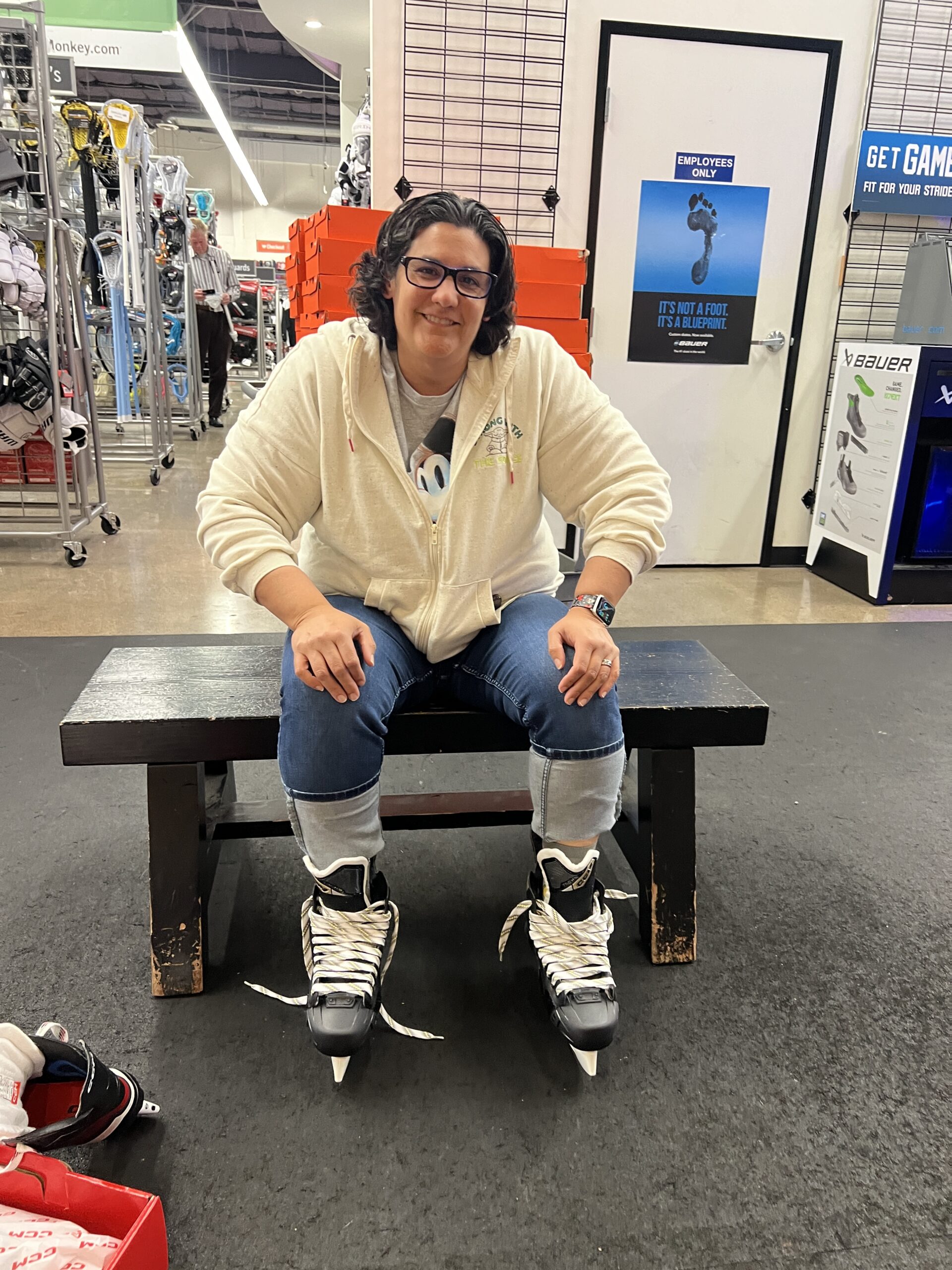 Woman sitting smiling in a sports store with new skates on for a sustainable weight loss plan